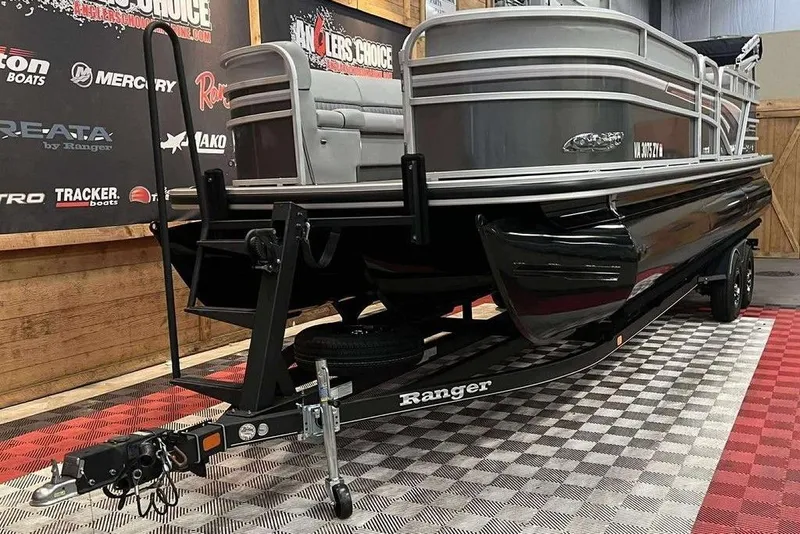 Slide: The Image of 2021 Ranger 243C pontoon boat on trailer in showroom with branded backdrop. - 6