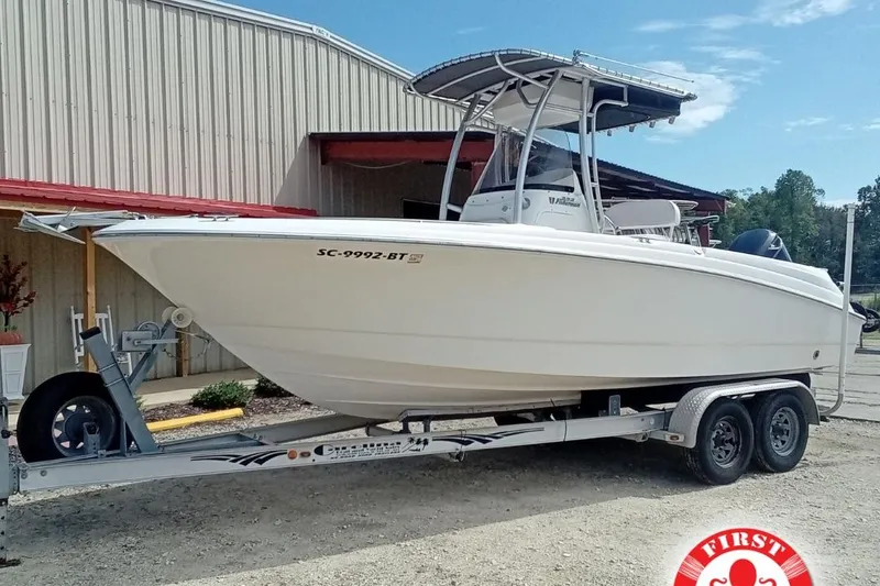 Slide: The Image of 2006 Wellcraft 232 Fisherman boat on trailer, parked outside a metal building. - 0