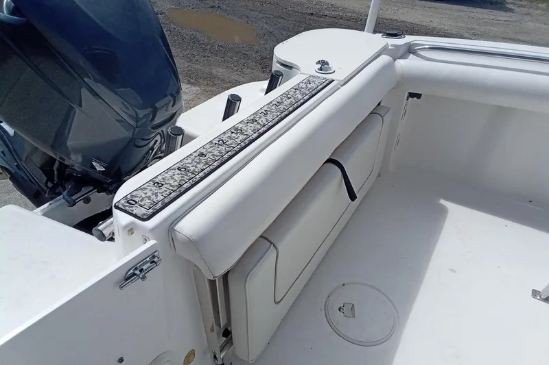 Slide: The Image of 2006 Wellcraft 232 Fisherman boat interior with white seating and engine view. - 10