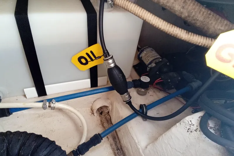 Slide: The Image of 2006 Wellcraft 232 Fisherman boat engine compartment with oil tank and hoses. - 12