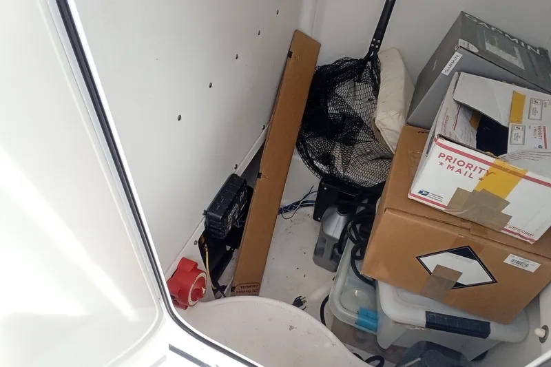 Slide: The Image of Storage area inside 2006 Wellcraft 232 Fisherman boat with boxes and fishing gear. - 17