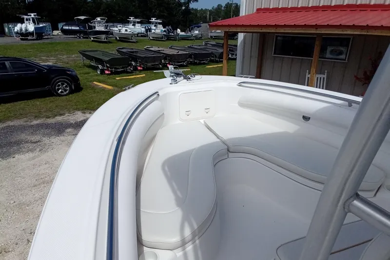 Slide: The Image of 2006 Wellcraft 232 Fisherman boat interior with white seating, parked outdoors near other boats. - 18
