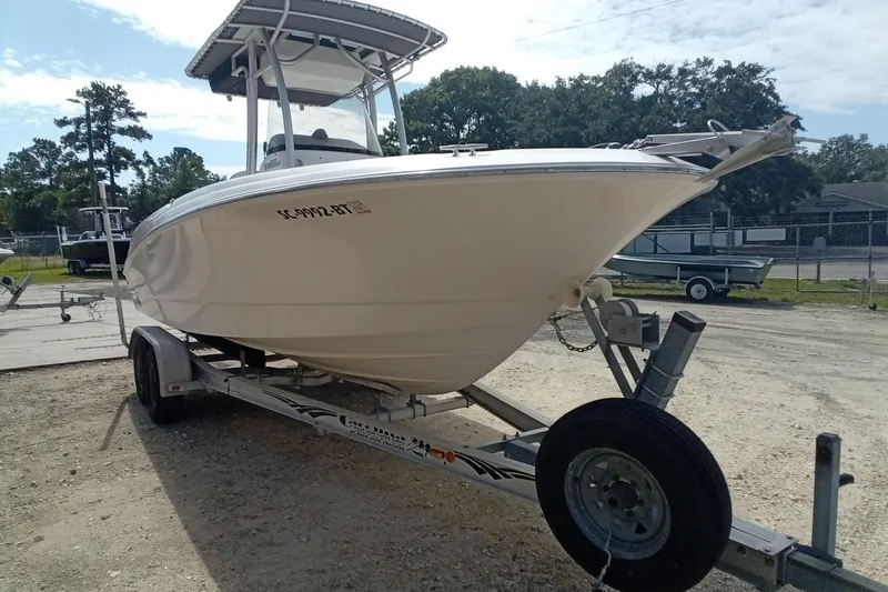 Slide: The Image of 2006 Wellcraft 232 Fisherman boat on trailer, parked outdoors under a partly cloudy sky. - 4