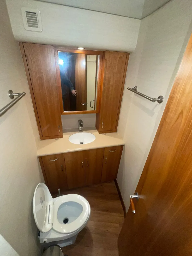 Slide: The Image of 2013 Hatteras GT63 yacht bathroom with wooden cabinets and modern fixtures. - 11