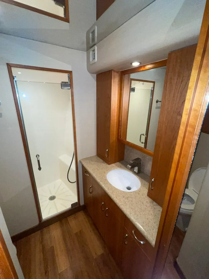Slide: The Image of 2013 Hatteras GT63 yacht bathroom with wood cabinetry and shower. - 19
