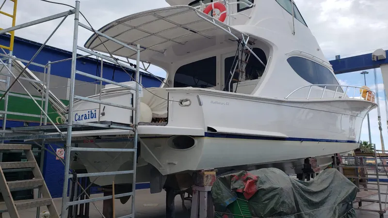 Slide: The Image of 2013 Hatteras GT63 yacht in dry dock, undergoing maintenance with scaffolding. - 3