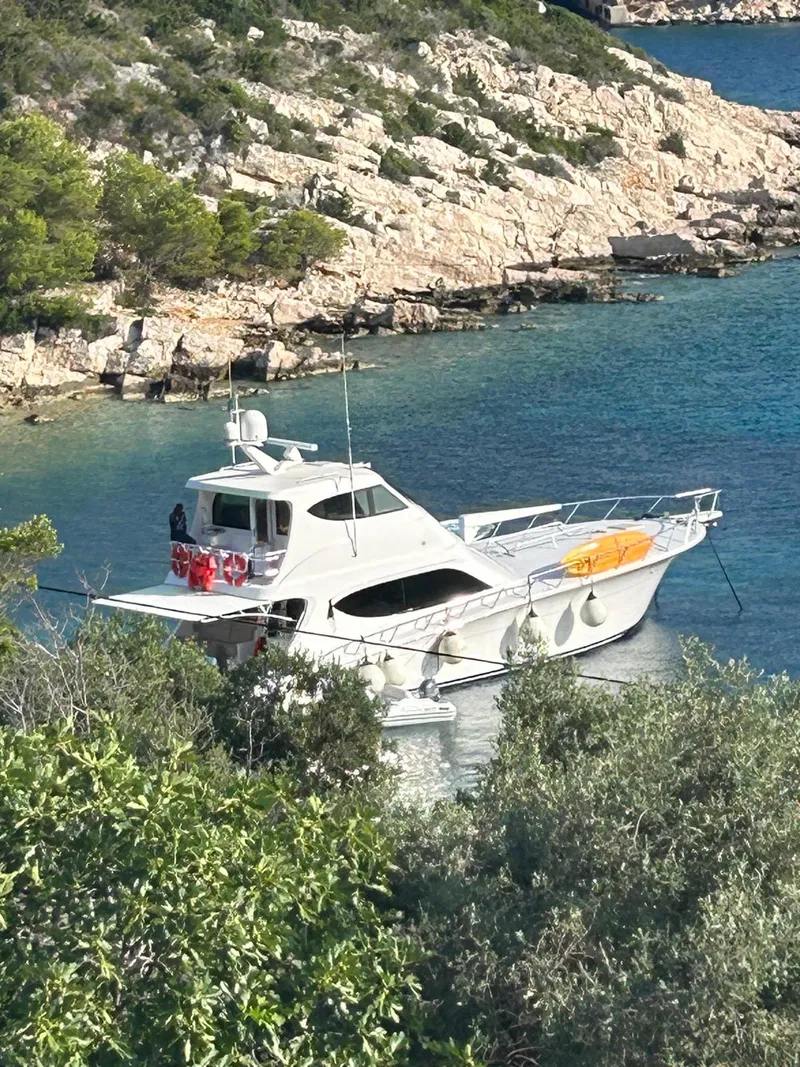 Slide: The Image of 2013 Hatteras GT63 yacht anchored in a scenic coastal bay. - 5