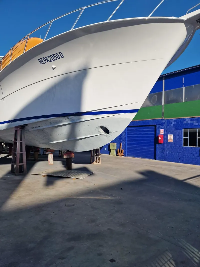 Slide: The Image of 2013 Hatteras GT63 yacht in dry dock, showcasing sleek hull design. - 6