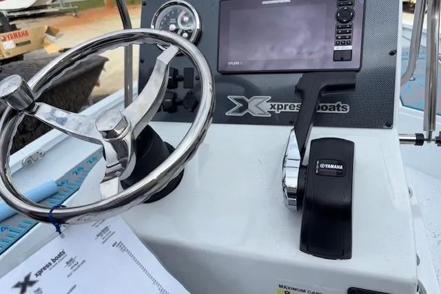 Slide: The Image of Steering console of 2026 Xpress H22B Bay boat with Yamaha controls and navigation display. - 16