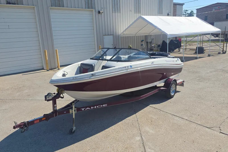 Slide: The Image of 2016 Tahoe 500 TS boat on trailer, parked outside a building. - 2
