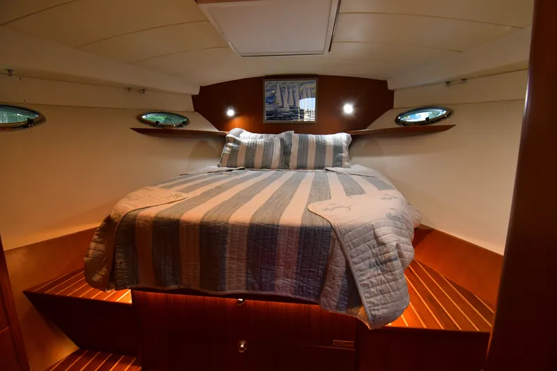Slide: The Image of Cozy cabin interior of 2021 Hylas M44 yacht with striped bedding and wooden accents. - 16