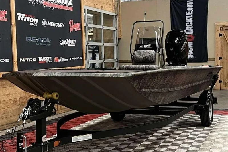 Slide: The Image of 2026 Tracker Grizzly 1860 CC boat on display in showroom with promotional banners. - 3