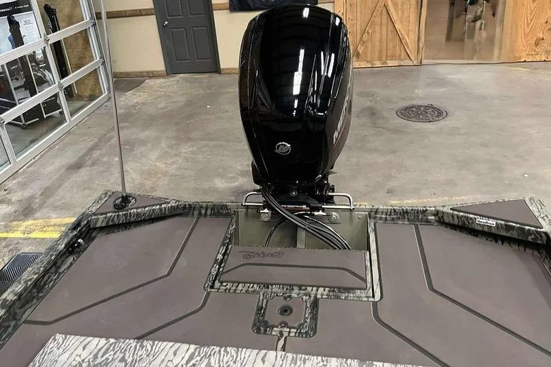 Slide: The Image of 2026 Tracker Grizzly 1860 CC boat with a powerful outboard motor in a showroom. - 4