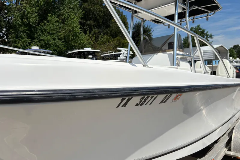 Slide: The Image of 1998 Mako 221 Center Console boat with registration number, parked outdoors. - 1