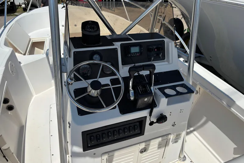 Slide: The Image of 1998 Mako 221 Center Console boat dashboard with steering wheel and controls. - 10
