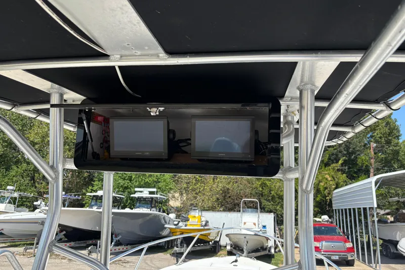 Slide: The Image of 1998 Mako 221 Center Console with dual monitors under T-top, surrounded by boats. - 16