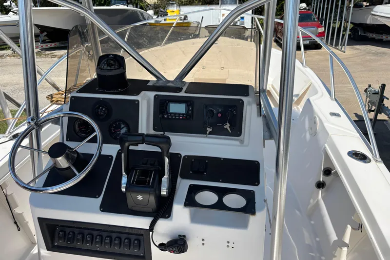 Slide: The Image of 1998 Mako 221 Center Console boat dashboard with steering wheel and controls. - 17