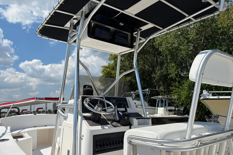 Slide: The Image of 1998 Mako 221 Center Console boat with T-top, steering wheel, and seating, under a blue sky. - 5