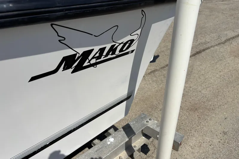 Slide: The Image of 1998 Mako 221 Center Console boat logo on white hull, outdoor setting. - 6