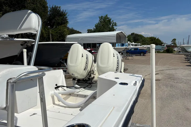 Slide: The Image of 1998 Mako 221 Center Console boat with Suzuki engines in a marina setting. - 7