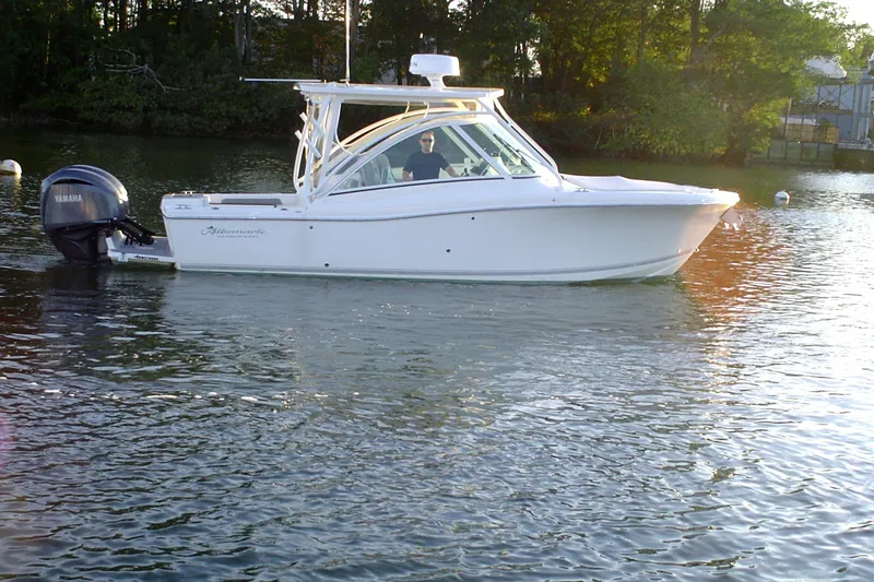 The Image of 2024 Albemarle 27 Dual Console boat on calm water, surrounded by trees. - 0
