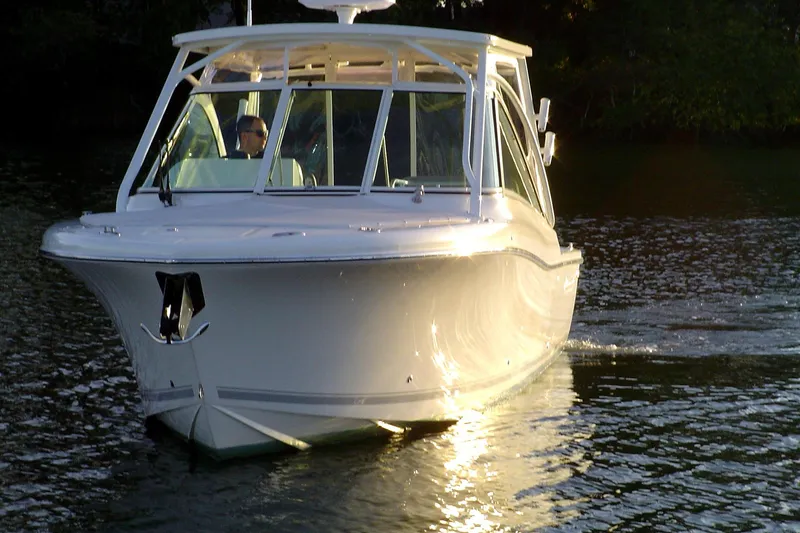 Slide: The Image of 2024 Albemarle 27 Dual Console boat cruising on a serene waterway at sunset. - 2