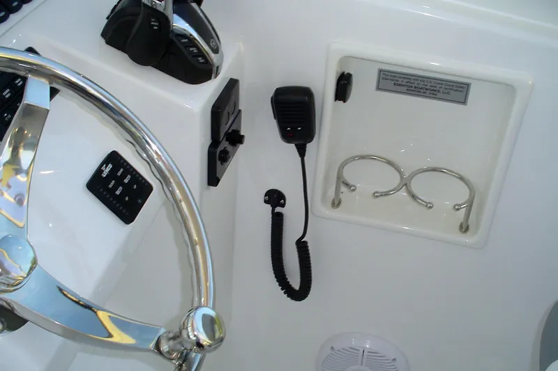 Slide: The Image of 2024 Albemarle 27 Dual Console helm with steering wheel, controls, and cup holders. - 28