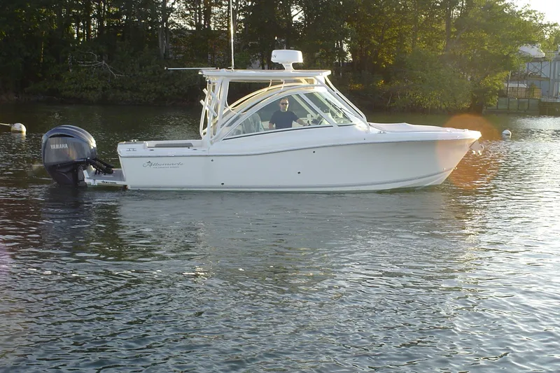 Slide: The Image of 2024 Albemarle 27 Dual Console boat on calm water with Yamaha outboard motor. - 6