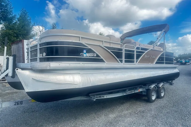 Slide: The Image of 2011 Godfrey Aqua Patio 240 Pontoon boat on trailer under cloudy sky. - 0
