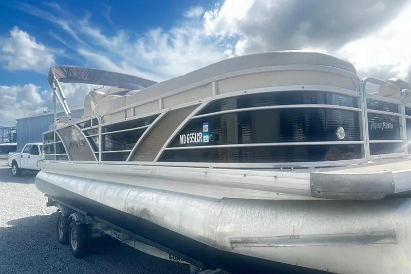 Slide: The Image of 2011 Godfrey Aqua Patio 240 Pontoon boat on trailer under cloudy sky. - 1