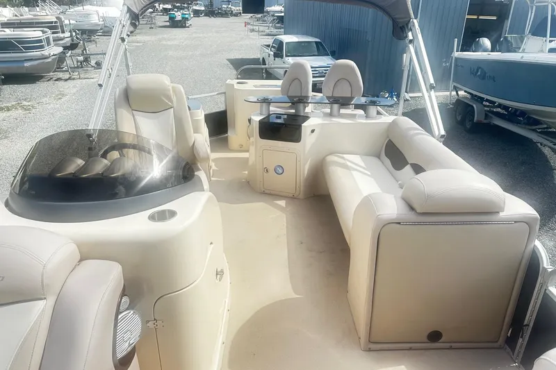 Slide: The Image of 2011 Godfrey Aqua Patio 240 Pontoon interior with beige seating and steering console. - 11