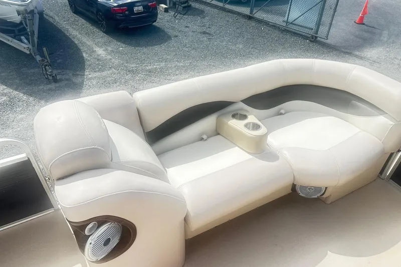 Slide: The Image of 2011 Godfrey Aqua Patio 240 Pontoon boat interior with beige seating and cup holders. - 13