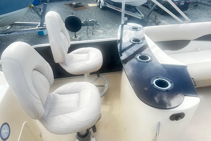 Slide: The Image of 2011 Godfrey Aqua Patio 240 Pontoon interior with white seating and cup holders. - 18