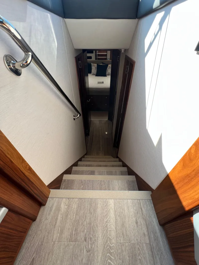 Slide: The Image of Staircase inside 2022 Riviera 505 SUV yacht, featuring wood accents and modern design. - 29