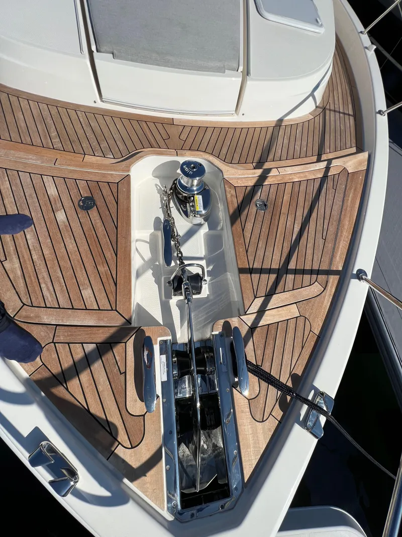 Slide: The Image of Riviera 505 SUV 2022 yacht deck with teak wood finish and anchor system. - 46