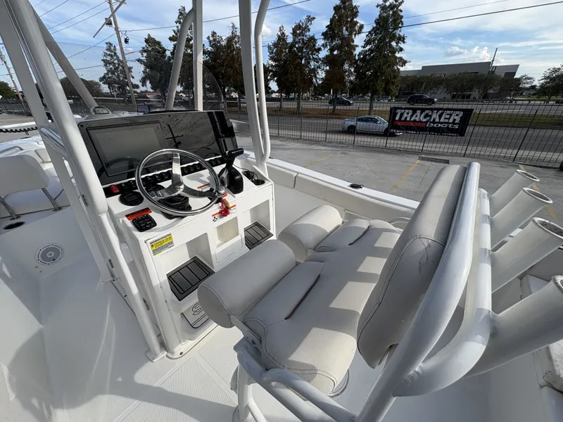 Slide: The Image of 2021 Sea Hunt Ultra 219 boat interior with cushioned seating and steering console. - 15