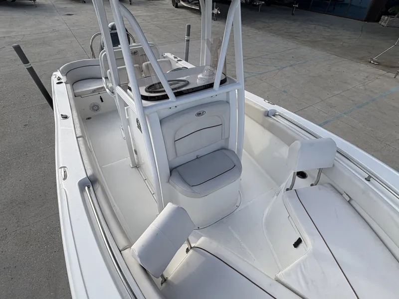 Slide: The Image of 2021 Sea Hunt Ultra 219 boat interior with seating and console, parked on concrete. - 8
