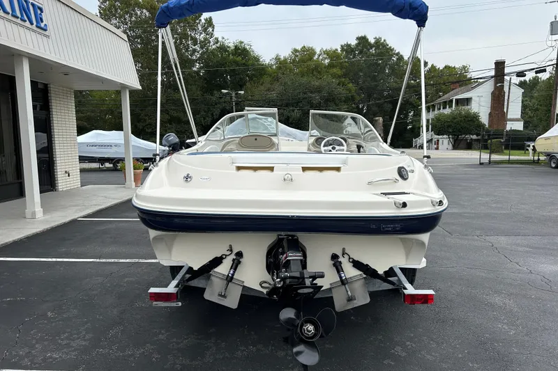 Slide: The Image of 2002 Bayliner 195 Capri boat, rear view, parked outdoors with blue canopy. - 12