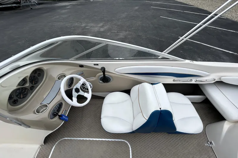 Slide: The Image of 2002 Bayliner 195 Capri boat interior with steering wheel, dashboard, and white seating. - 22