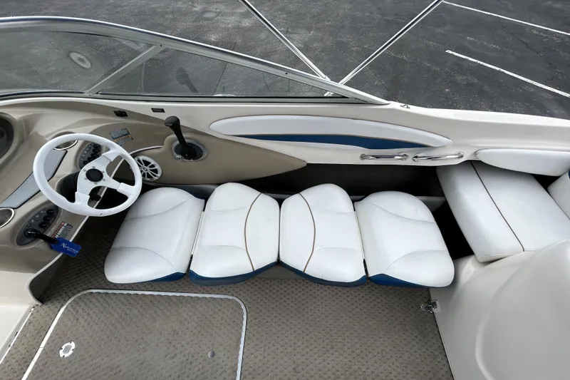 Slide: The Image of Interior of a 2002 Bayliner 195 Capri boat with white seating and steering wheel. - 28