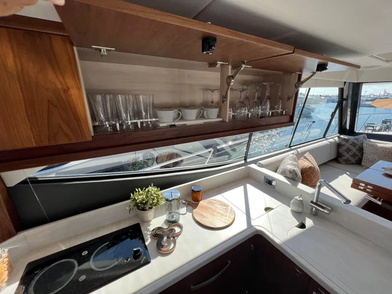 Slide: The Image of Luxurious 2022 Riviera 505 SUV yacht kitchen with elegant cabinetry and ocean view. - 22