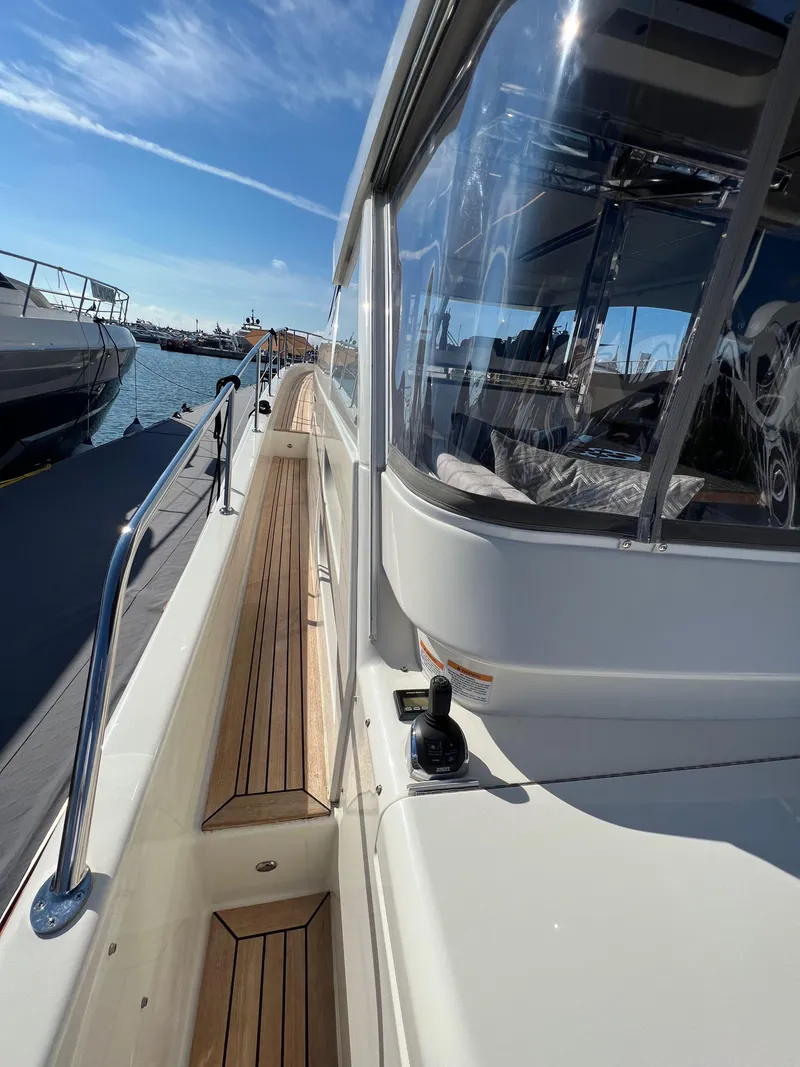 Slide: The Image of 2022 Riviera 505 SUV yacht with sleek design, docked at marina under clear blue sky. - 44