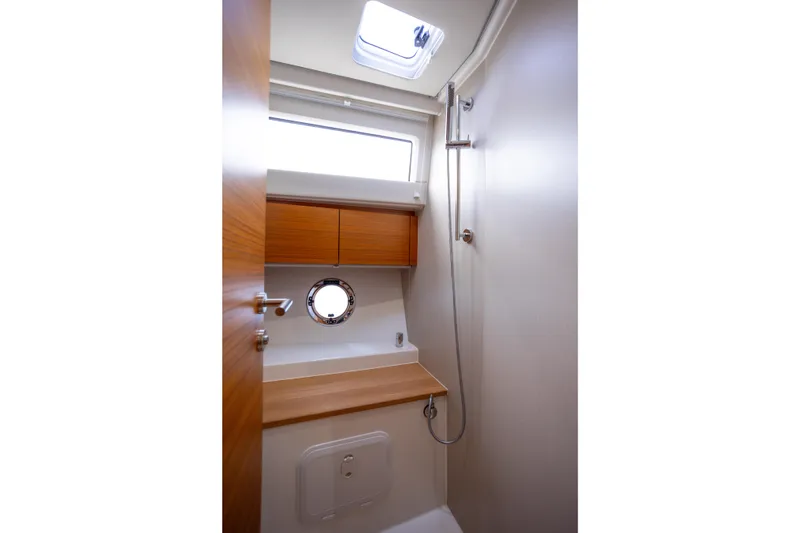 Slide: The Image of 2023 Greenline 48 Fly yacht bathroom with wooden cabinetry and porthole window. - 11