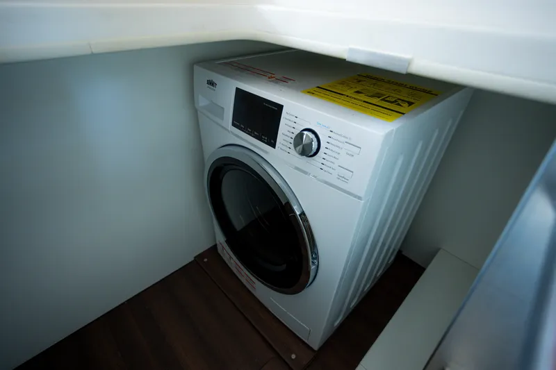 Slide: The Image of Washing machine inside 2023 Greenline 48 Fly yacht, compact laundry area. - 16