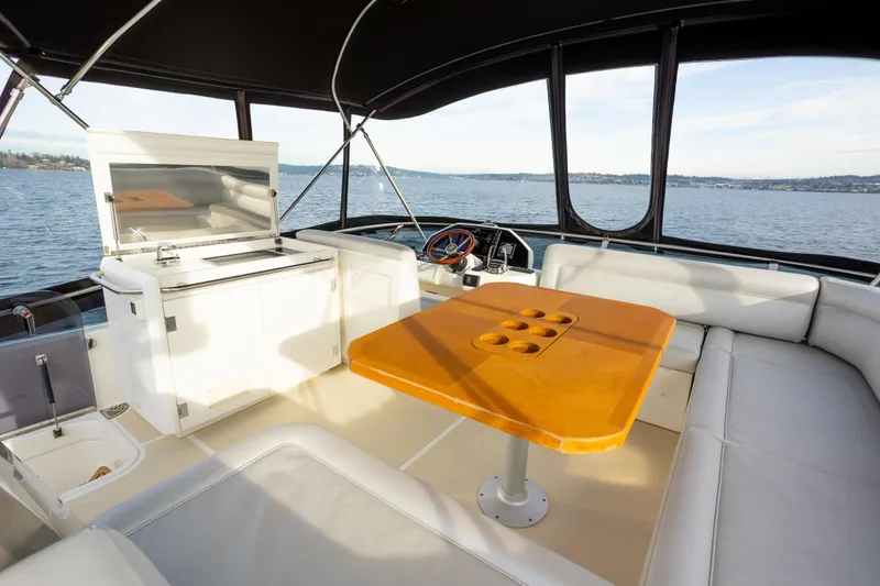 Slide: The Image of 2023 Greenline 48 Fly yacht interior with seating and table on open water. - 18