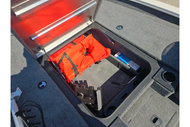 Slide: The Image of 2024 Tracker Pro Team 190 TX boat storage compartment with life jacket and accessories. - 14