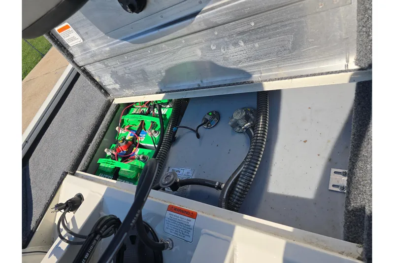 Slide: The Image of 2024 Tracker Pro Team 190 TX boat battery compartment with wiring and components. - 17