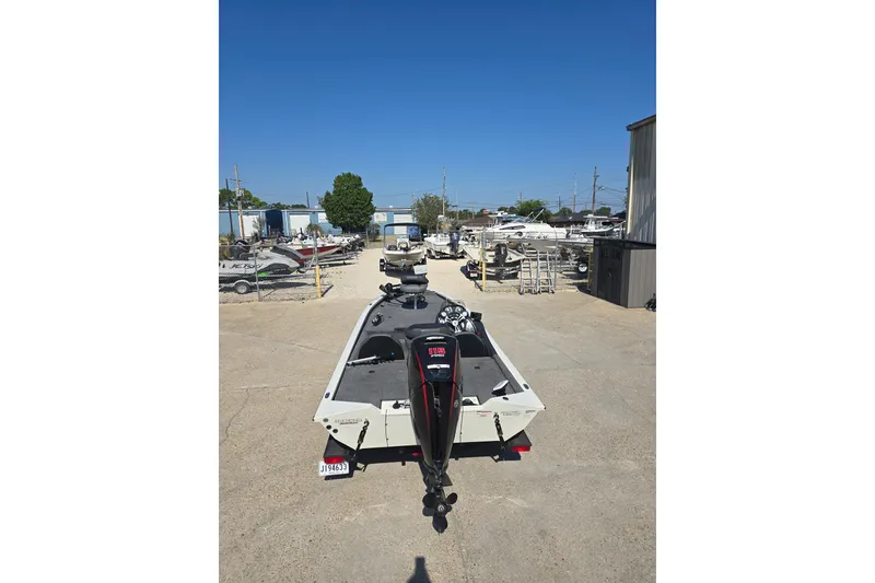 Slide: The Image of 2024 Tracker Pro Team 190 TX boat in a marina storage area under clear blue sky. - 5