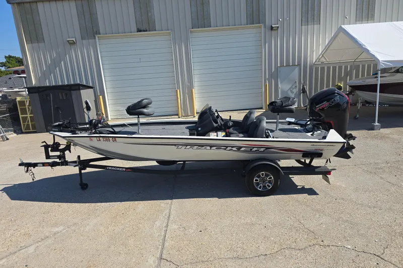 Slide: The Image of 2024 Tracker Pro Team 190 TX boat parked outside a warehouse. - 7
