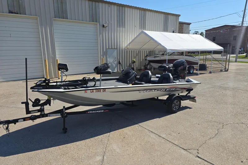 Slide: The Image of 2024 Tracker Pro Team 190 TX boat on trailer outside a garage. - 8